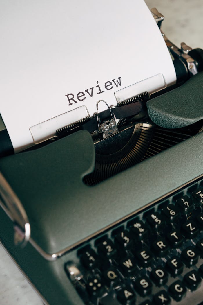 Close-up of a vintage typewriter typing the word 'Review' on paper.